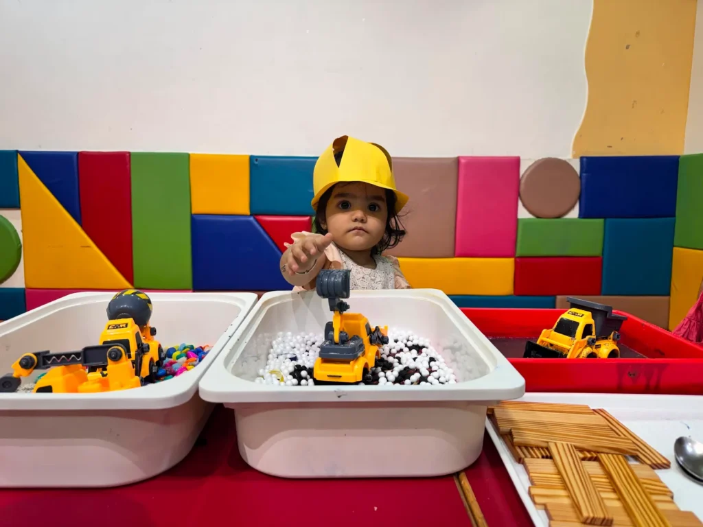 Child playing with toy trucks at Eager Beaver